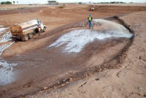 Truck and worker laying bentonite clay pond liner